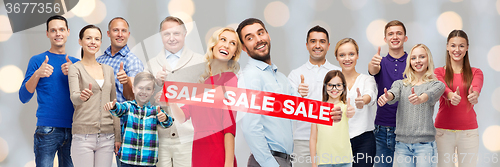 Image of happy people with red sale sign showing thumbs up