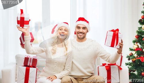 Image of happy couple at home with christmas gift boxes