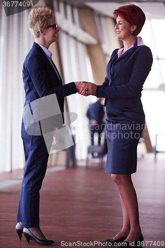 Image of business womans make deal and handshake