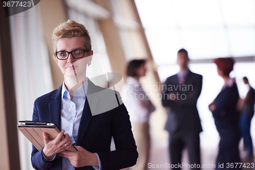 Image of business woman  at office with tablet  in front  as team leader