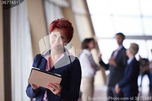 Image of business woman  at office with tablet  in front  as team leader