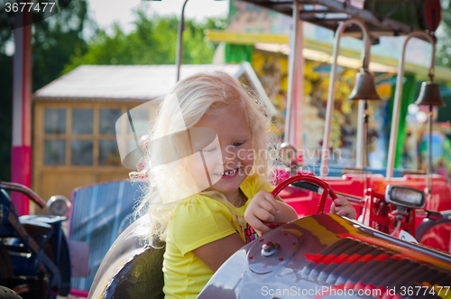 Image of Child goes for a drive on a children\'s attraction