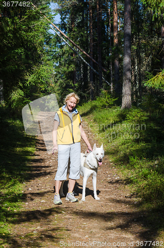 Image of Woman with a dog on a walk in the park