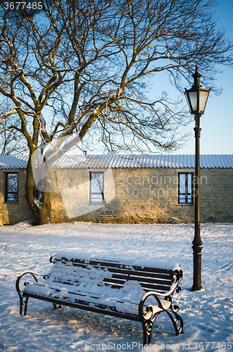 Image of Bench and street lamp in the park winter Old Tallinn