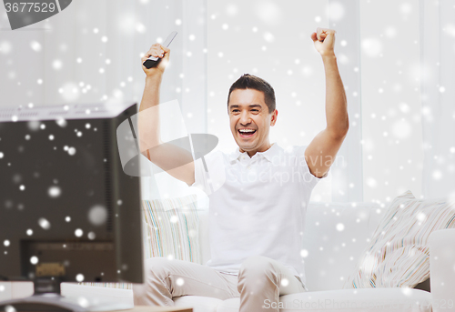 Image of smiling man watching sports at home