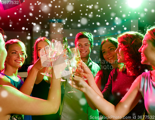 Image of smiling friends with glasses of champagne in club