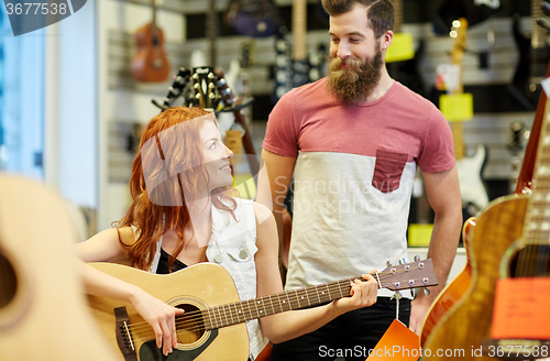 Image of couple of musicians with guitar at music store