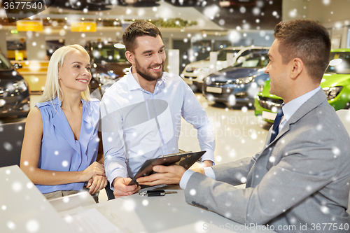 Image of happy couple with car dealer in auto show or salon