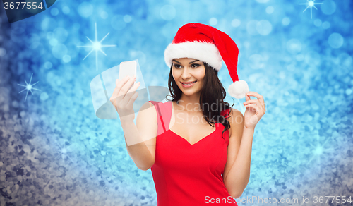 Image of woman in santa hat taking selfie by smartphone