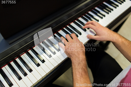 Image of close up of male hands playing piano