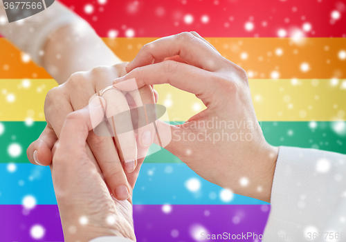 Image of close up of lesbian couple hands with wedding ring