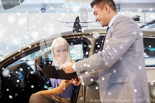 Image of happy woman with car dealer in auto show or salon