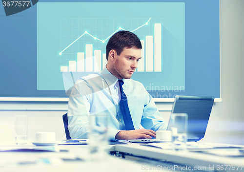 Image of businessman with laptop working in office