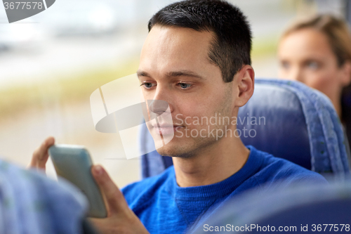 Image of happy man sitting in travel bus with smartphone