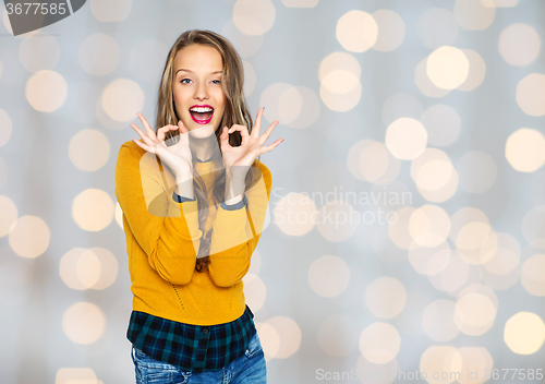 Image of happy young woman or teen showing ok hand sign