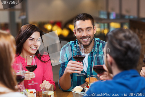 Image of friends dining and drinking wine at restaurant