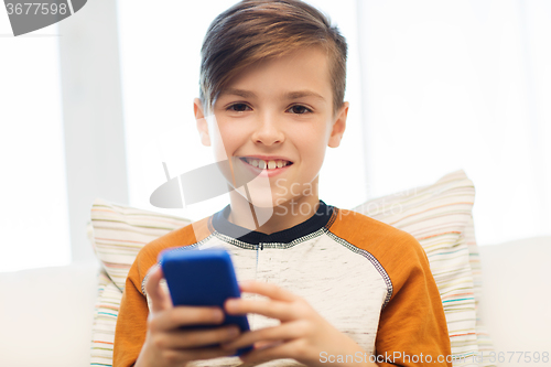 Image of boy with smartphone texting or playing at home