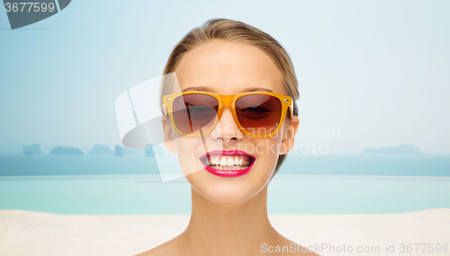 Image of happy young woman in sunglasses with pink lipstick