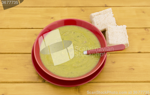 Image of Chunks of bread with bowl of green soup