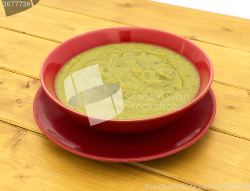 Image of Pea and ham soup in a red bowl 