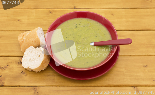 Image of Full bowl of soup with slices of baguette