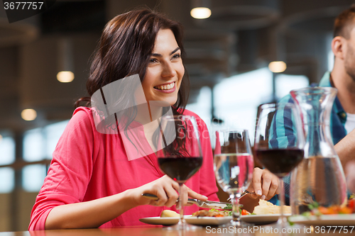 Image of happy woman having dinner at restaurant