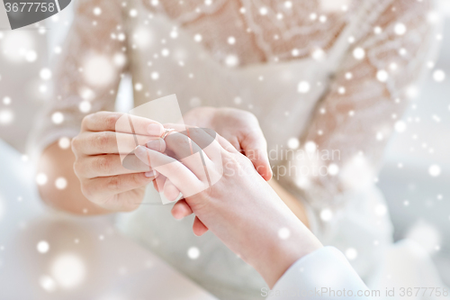 Image of close up of lesbian couple hands with wedding ring