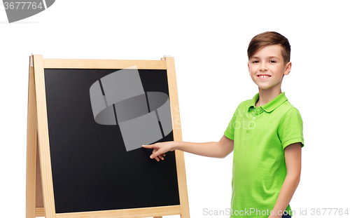 Image of happy boy with chalk and blank school blackboard