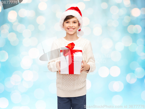 Image of smiling happy boy in santa hat with gift box