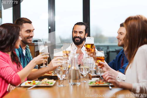 Image of friends dining and drinking beer at restaurant