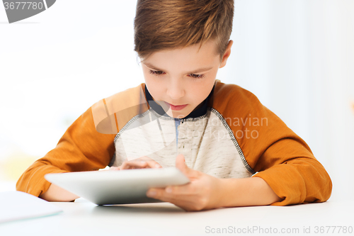 Image of close up of boy with tablet pc computer at home