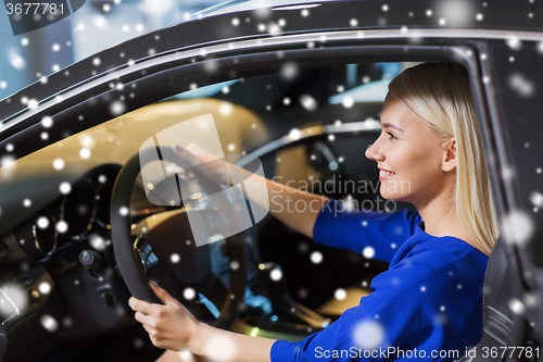 Image of happy woman inside car in auto show or salon