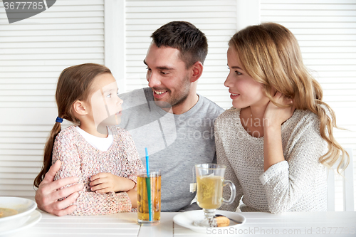 Image of happy family having dinner at restaurant or cafe
