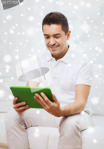 Image of smiling man working with tablet pc at home