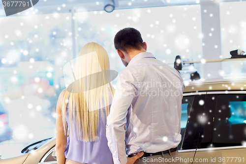 Image of couple choosing car in auto show or salon