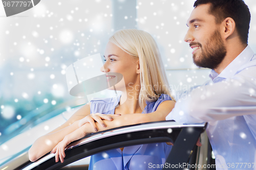 Image of happy couple buying car in auto show or salon