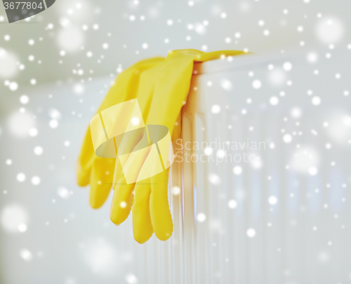 Image of close up of rubber gloves hanging on heater