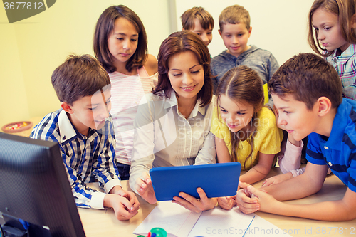 Image of group of kids with teacher and tablet pc at school