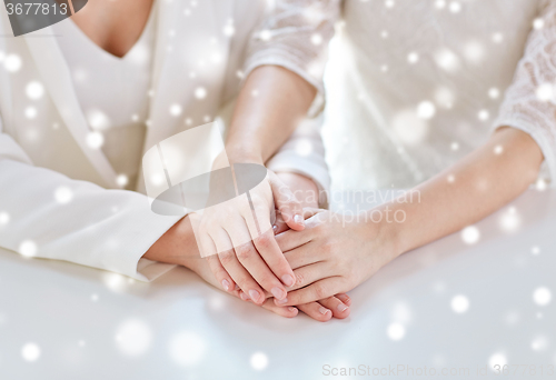 Image of close up of happy married lesbian couple hands