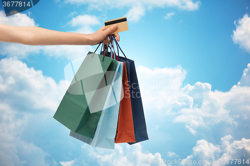 Image of close up of woman with shopping bags and bank card