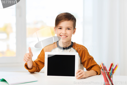 Image of happy boy with tablet pc showing thumbs up at home