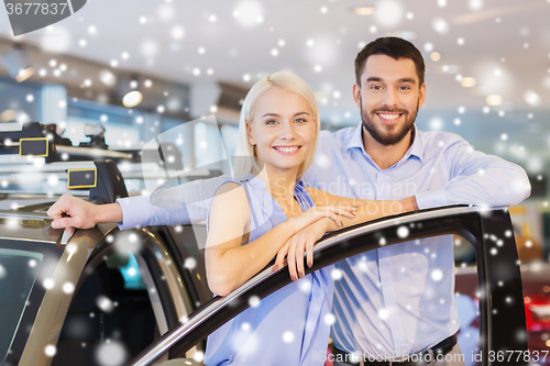 Image of happy couple with car in auto show or salon