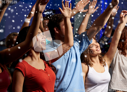 Image of smiling friends at concert in club