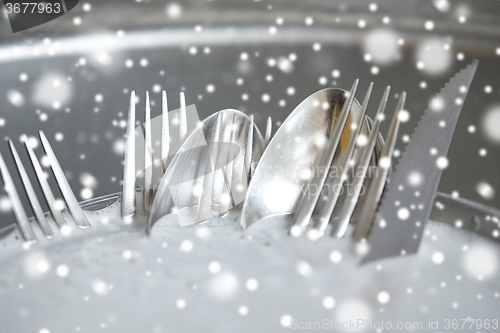 Image of close up of dirty dishes washing in kitchen sink