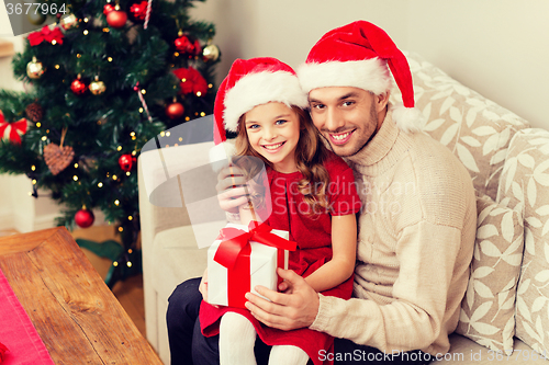 Image of smiling father and daughter holding gift box