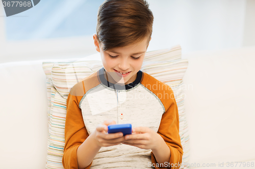 Image of boy with smartphone texting or playing at home