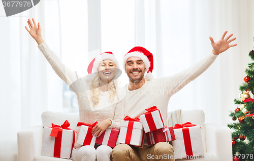 Image of happy couple at home with christmas gift boxes