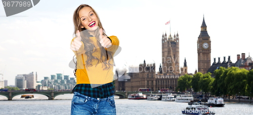 Image of happy young woman or teen girl showing thumbs up