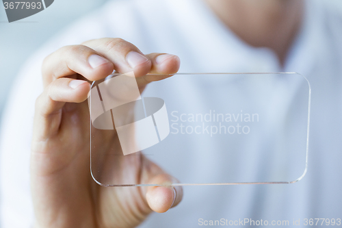 Image of close up of male hand with transparent smartphone