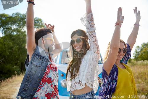 Image of happy young hippie friends dancing outdoors